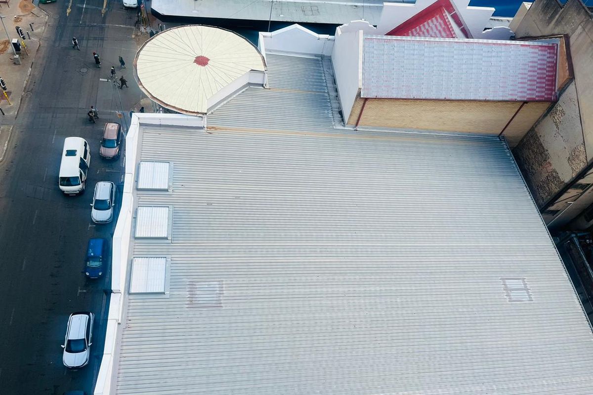 Aerial view of the commercial property roof featuring corrugated metal roofing, integrated skylights, and a circular architectural roof feature.