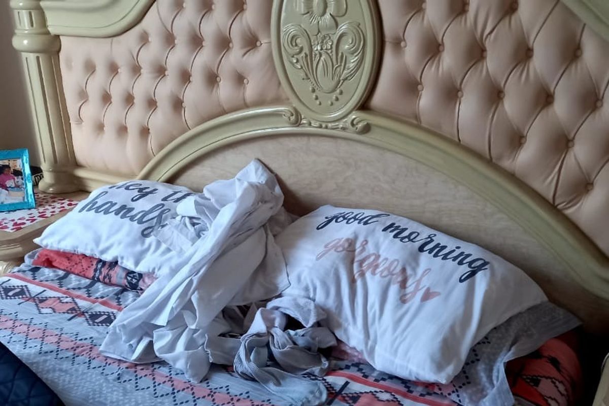 A close-up view of a bedroom featuring a large, ornate, tufted headboard.
