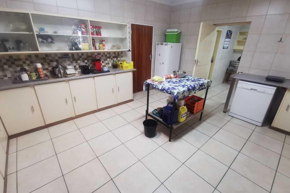 A functional kitchen featuring tiled flooring, wall-mounted cabinetry, and a dedicated dishwasher space, offering a practical layout for daily meal preparation.