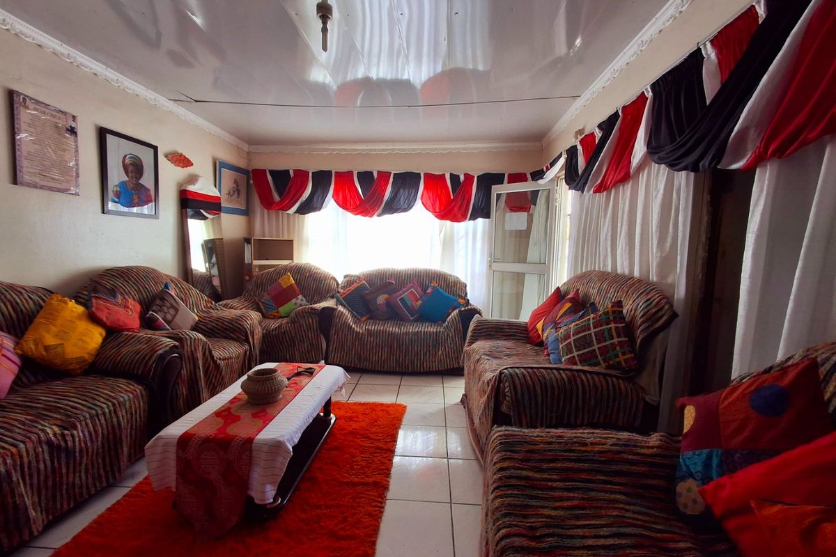 A living room featuring tiled flooring and a glossy ceiling finish, providing a functional space for relaxation.