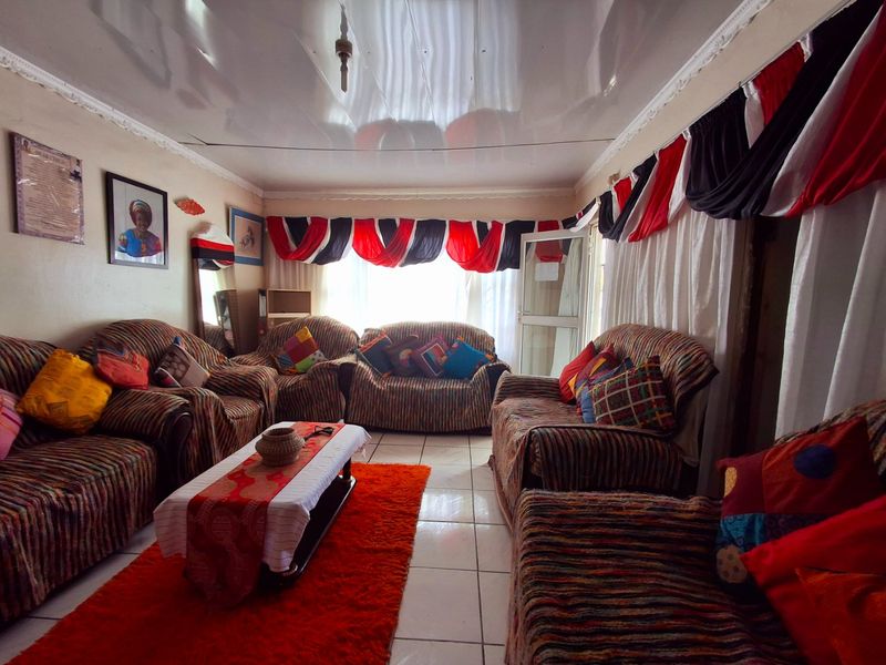A living room featuring tiled flooring and a glossy ceiling finish, providing a functional space for relaxation.