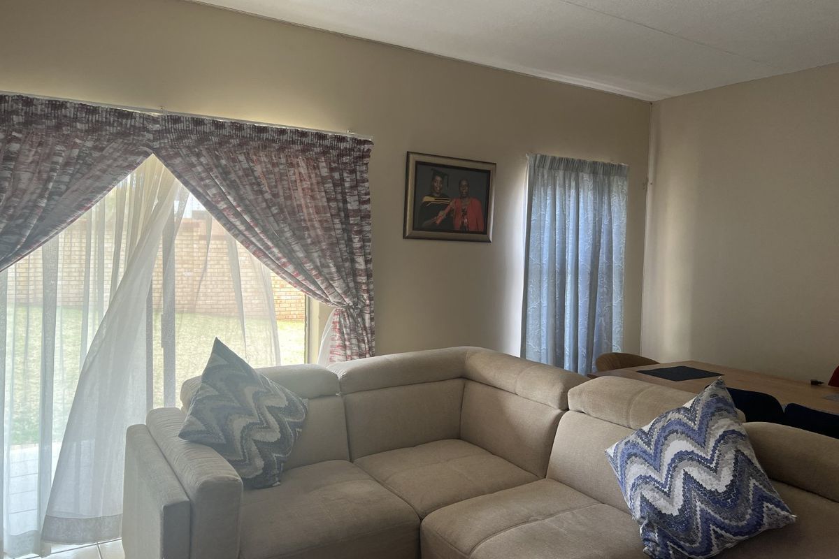 A living room area featuring tiled flooring and a sliding glass door providing access to the exterior.