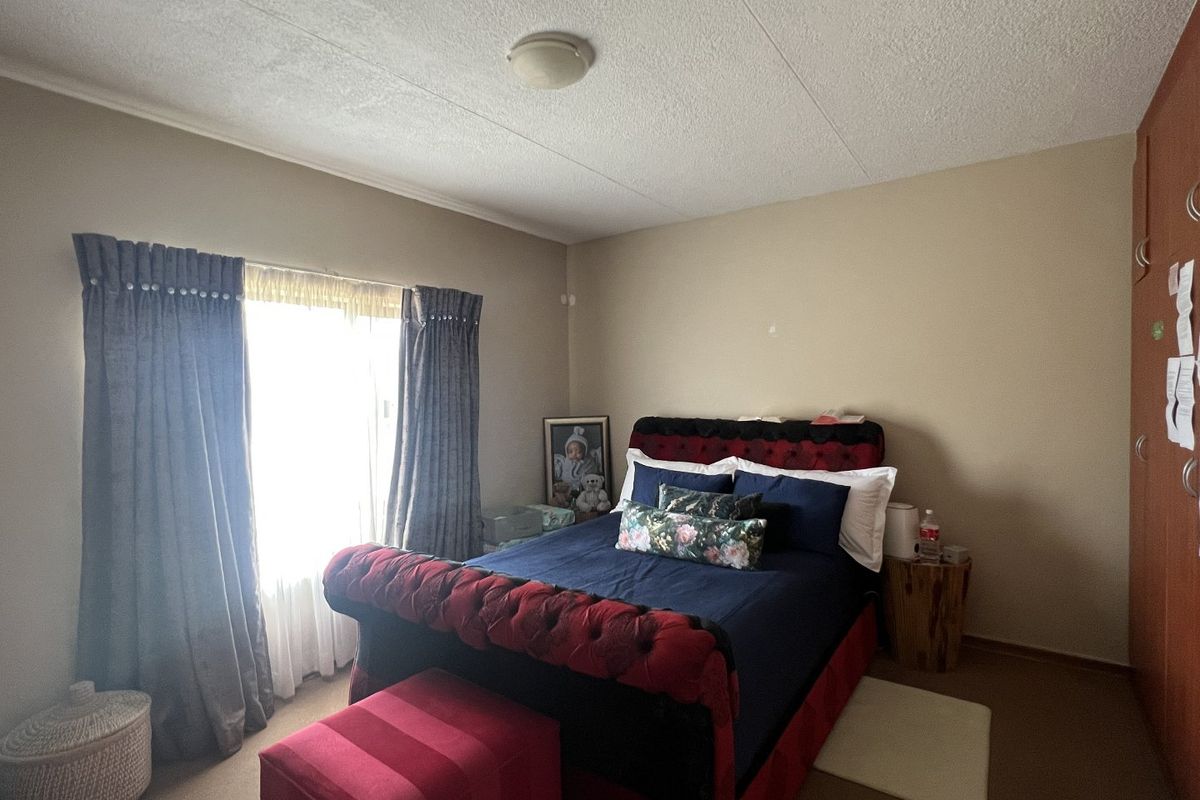 A standard bedroom featuring neutral wall tones, carpeted flooring, and a built-in wardrobe, offering a functional and comfortable living space.