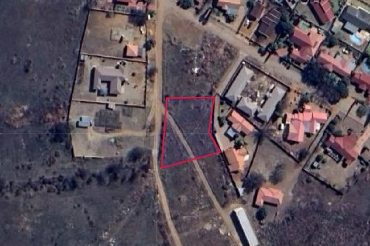 An aerial view of a vacant residential plot, highlighting the property boundaries within an established neighborhood setting.
