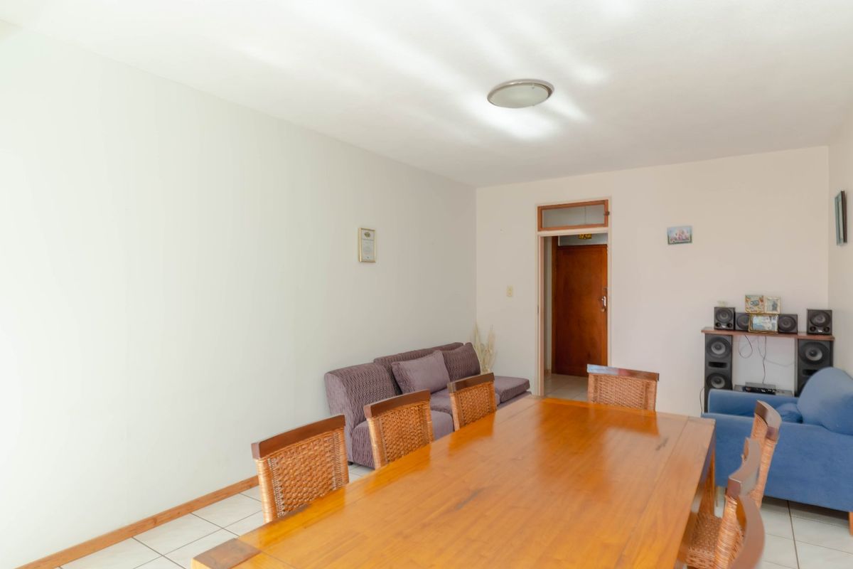 A functional living and dining area featuring tiled flooring and neutral walls, providing a versatile space for relaxation and meals.