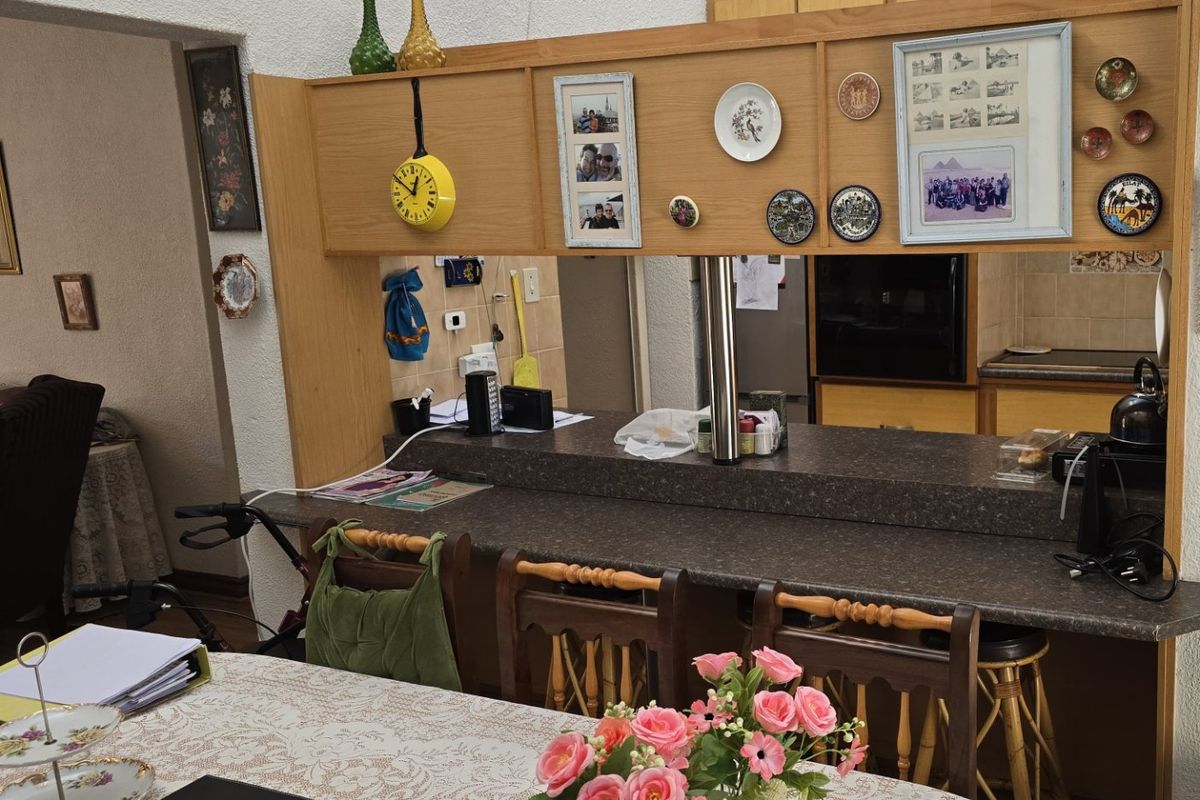 Open plan kitchen and dining area featuring a breakfast bar with laminate cabinetry and textured wall finishes.