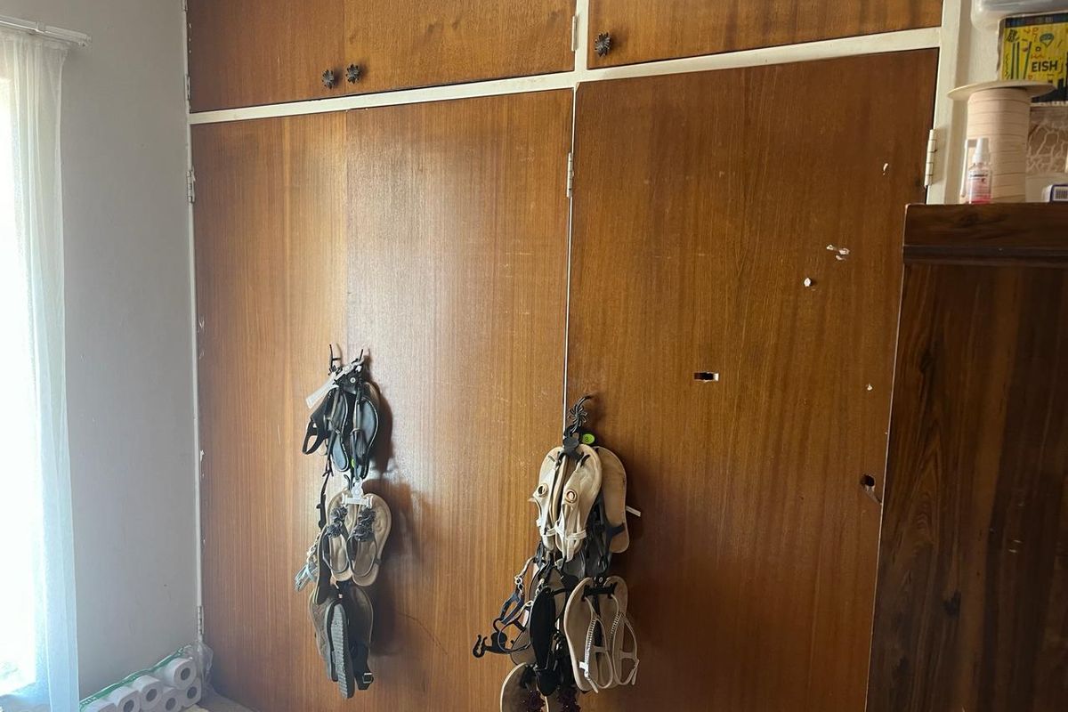 Bedroom featuring dated built-in wooden cupboards with visible surface damage and wear.