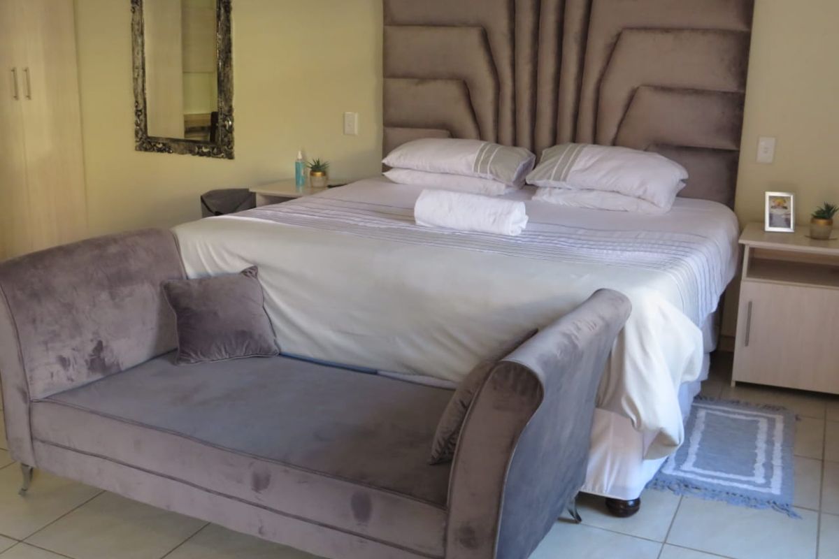 A well-maintained bedroom featuring tiled flooring and built-in cupboards, offering a clean and functional living space.
