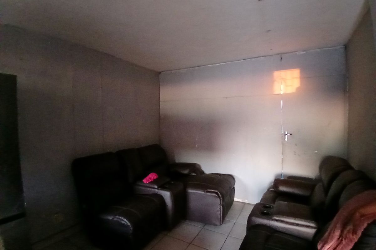 A living room area featuring tiled flooring and plain wall surfaces, requiring cosmetic updates to improve the overall aesthetic and finish.