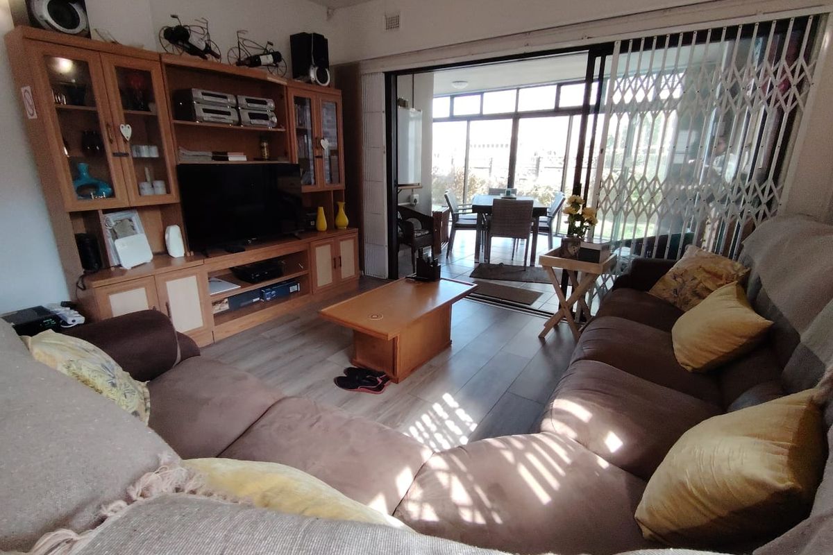 Spacious living room featuring laminate flooring and large sliding glass doors that provide access to an adjoining patio area.