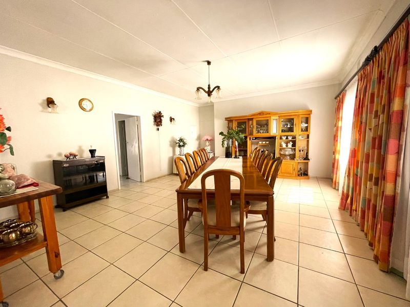 Spacious dining room featuring neutral tiled flooring and a coved ceiling, providing a functional and well-lit area for family meals and entertaining.