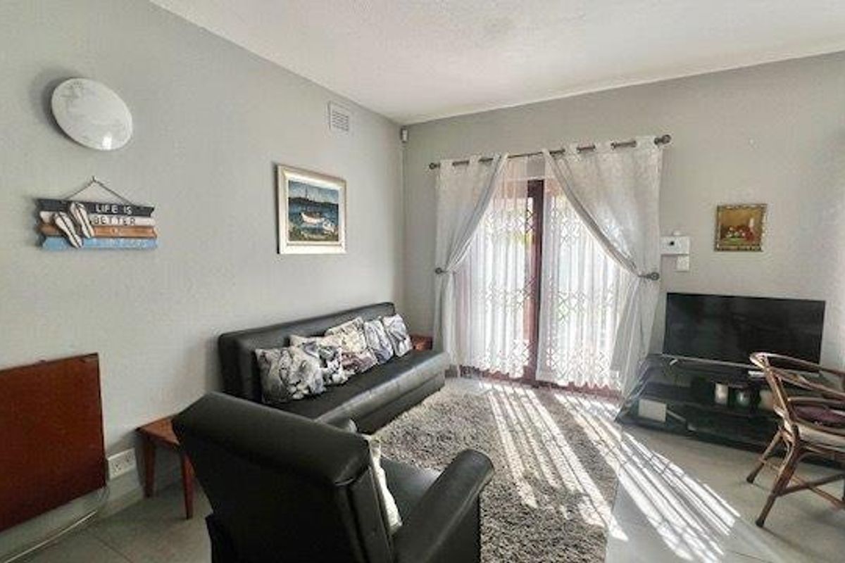 A bright living room featuring tiled flooring and sliding glass doors that provide access to the outdoor area.
