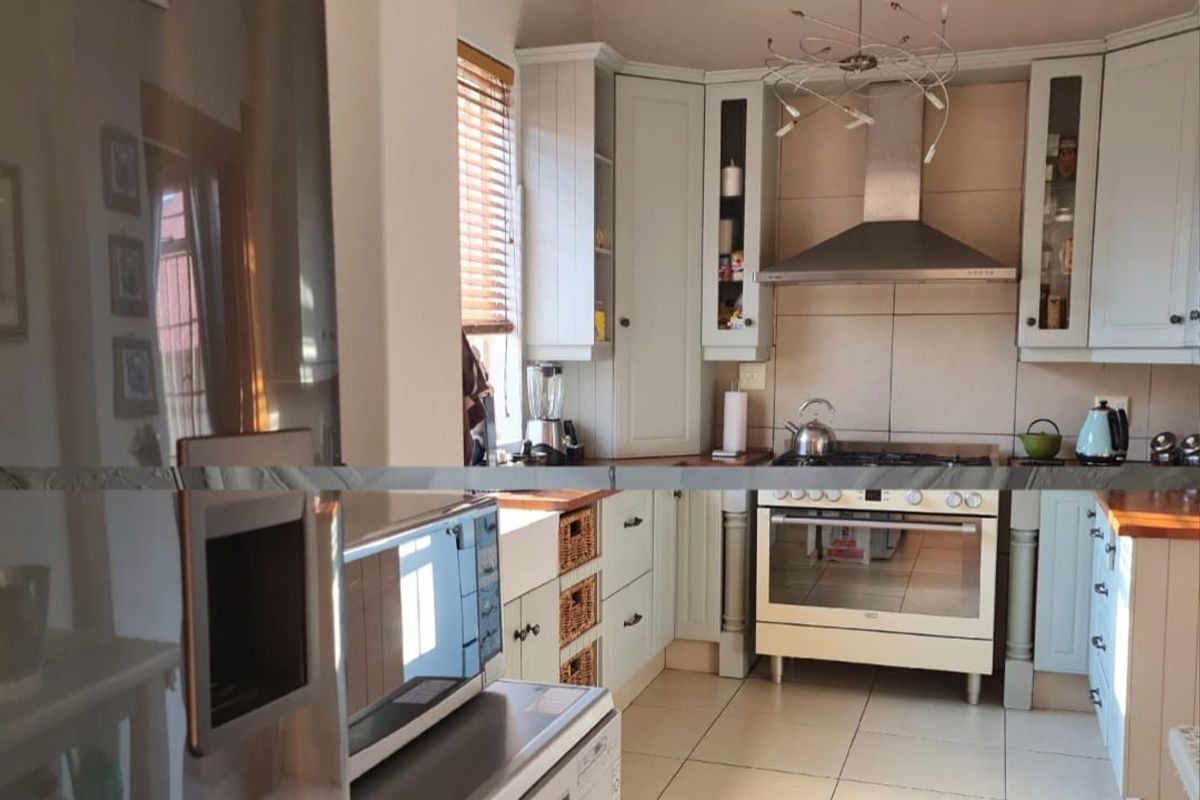 A well-appointed kitchen featuring classic cabinetry, timber countertops, a farmhouse sink, and a decorative ceiling, creating a warm and functional culinary space.