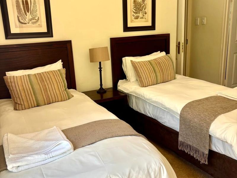 A twin bedroom featuring neutral wall finishes, carpeted flooring, and decorative coving, providing a functional and comfortable sleeping space.