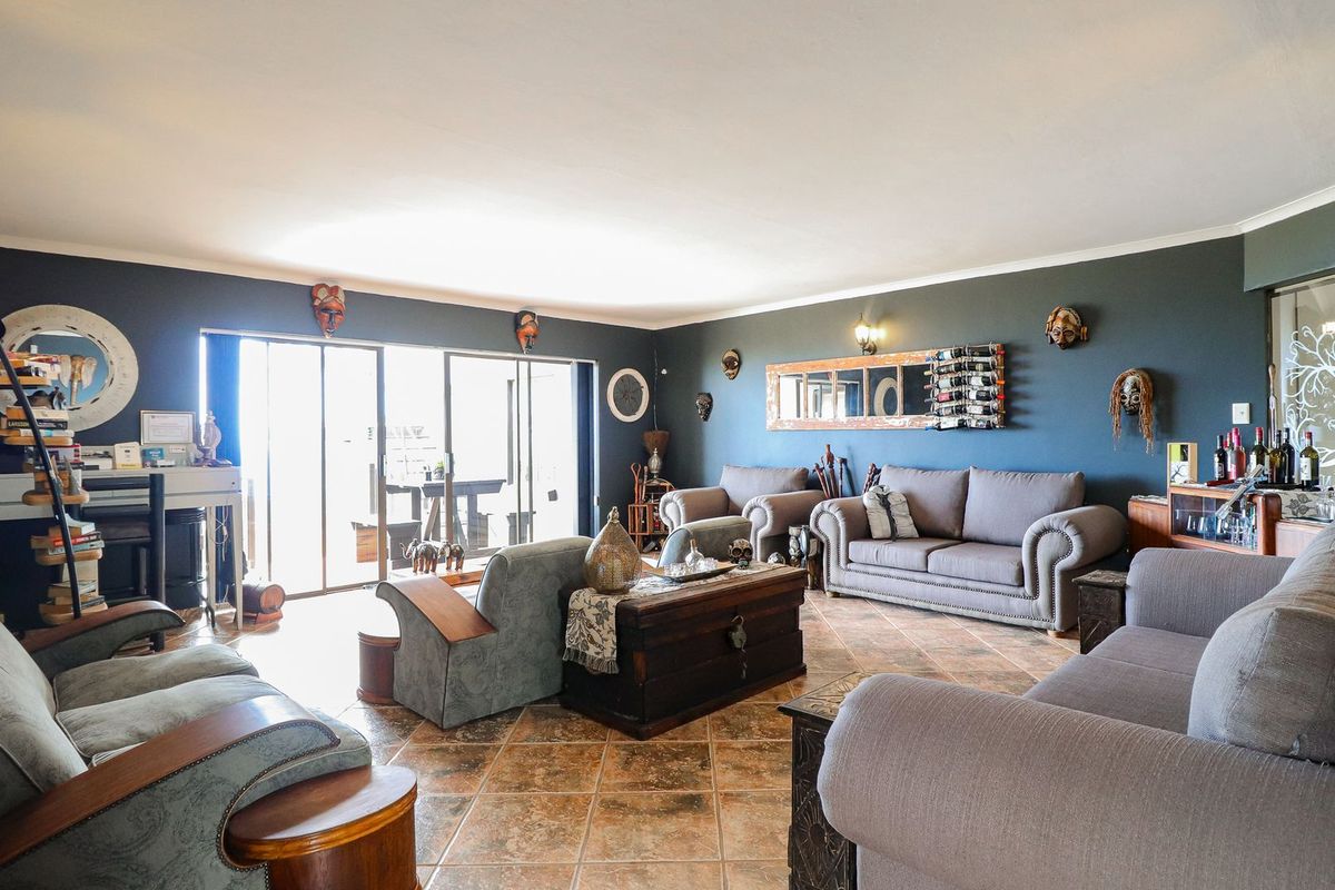 Spacious living room featuring tiled flooring and large sliding glass doors that provide ample natural light and access to the outdoor area.