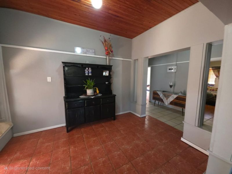 A living area featuring warm timber tongue and groove ceilings, ceramic floor tiles, and a classic archway leading to an adjacent space.