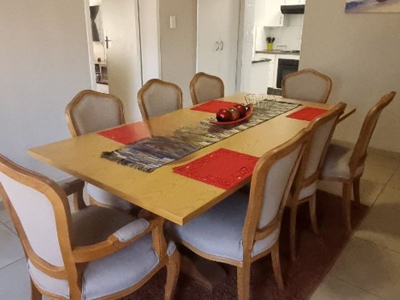 A dining area featuring tiled flooring and access to a kitchen, providing a functional space for family meals.