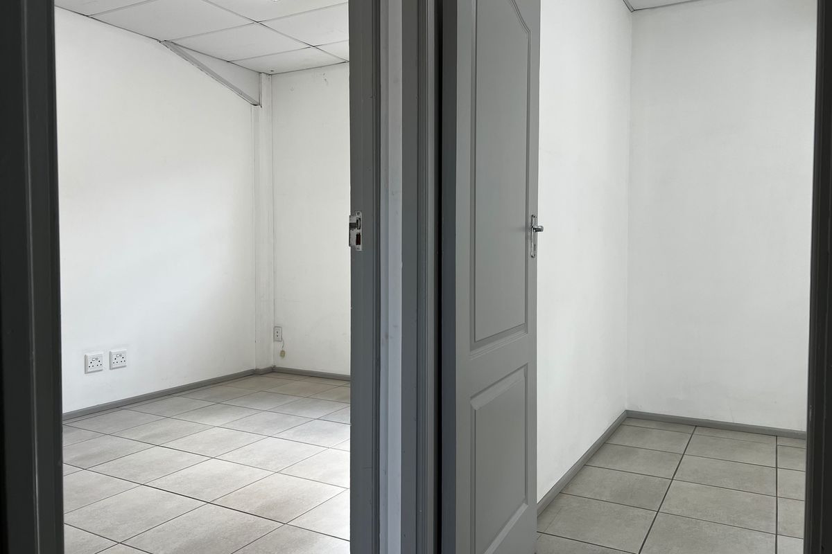 Two vacant office spaces featuring neutral tiled flooring, white walls, and suspended ceilings, offering a clean and functional commercial workspace.