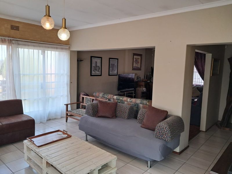 Open plan living area featuring tiled flooring, neutral wall finishes, and a large sliding glass door providing natural light.