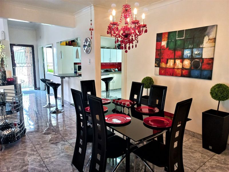 Dining area featuring tiled flooring and a breakfast bar overlooking the kitchen, with a coved ceiling and direct access to the entrance.
