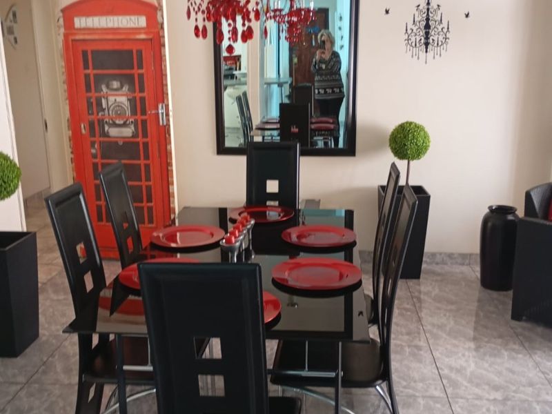 A dining room featuring tiled flooring and a prominent decorative chandelier, providing a functional space for meals.