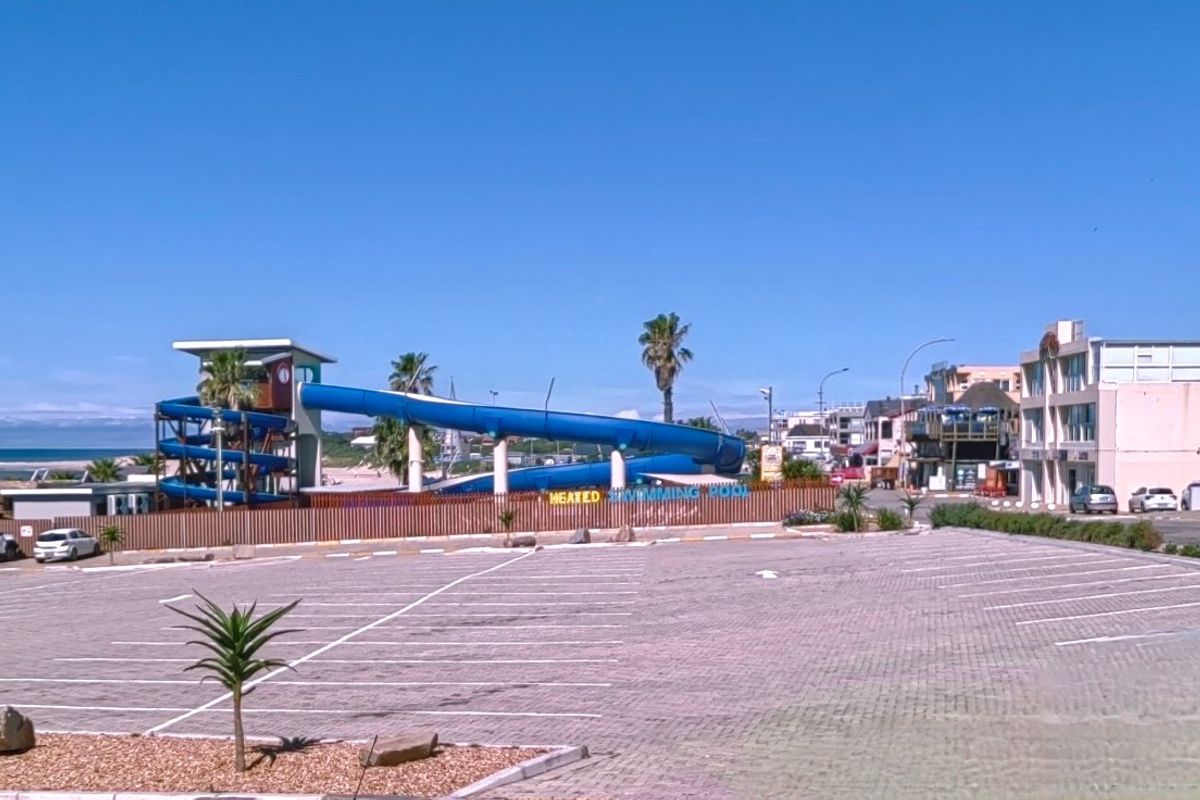 Commercial property exterior featuring a large paved parking area and a prominent water slide facility adjacent to the swimming pool area.
