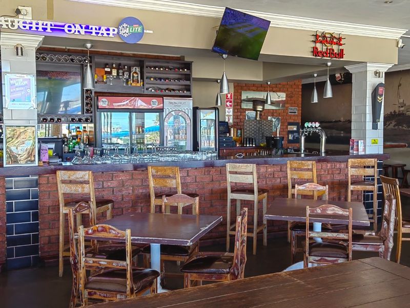 A commercial bar area featuring a brick-faced counter, integrated tap system, and exposed brick wall accents, providing a rustic and functional hospitality space.