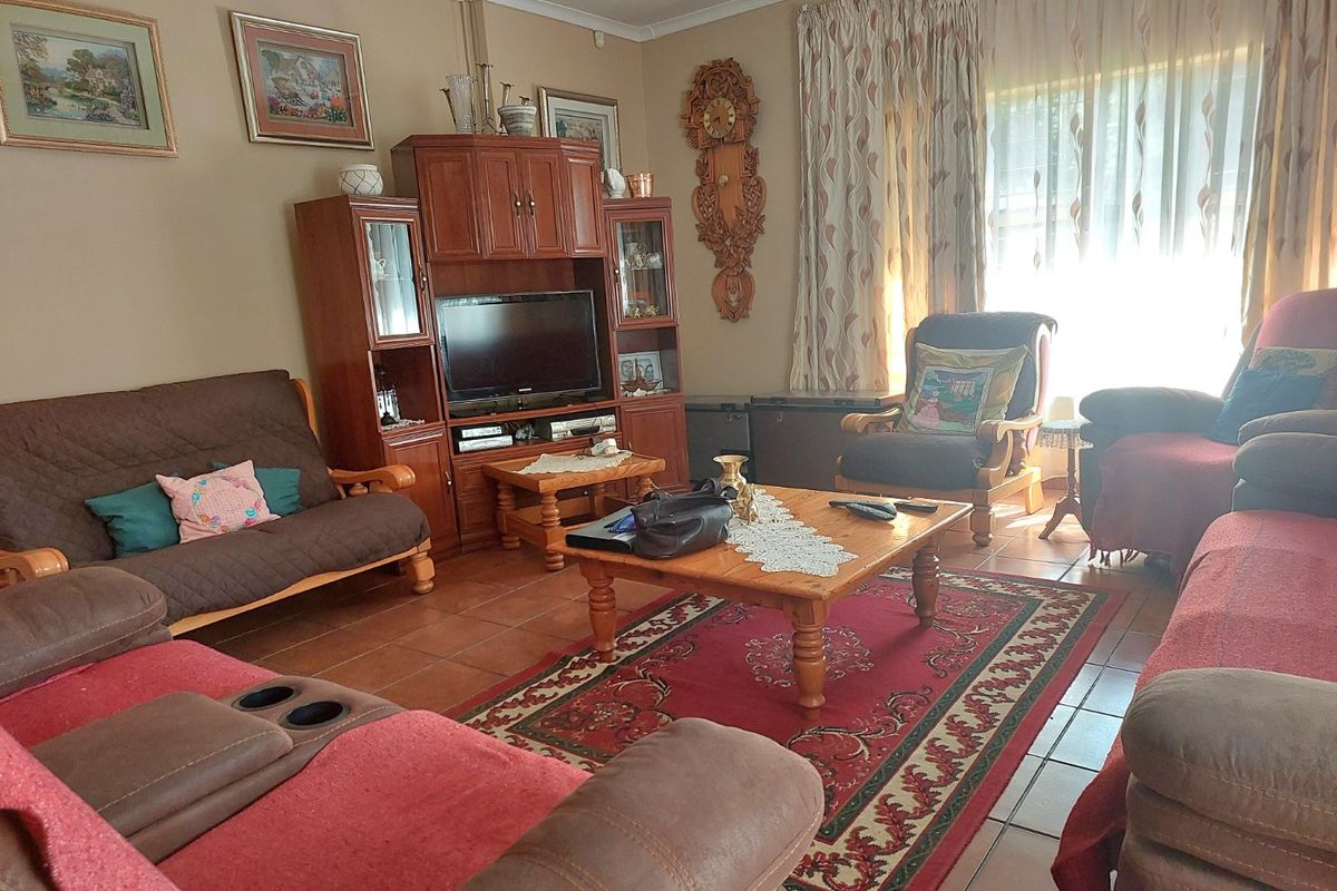 A traditional living room featuring tiled flooring and large windows with curtain treatments, offering a comfortable and functional space for relaxation.