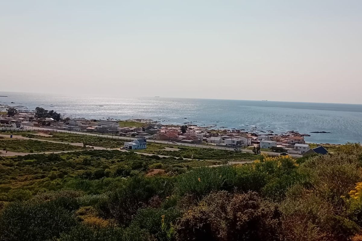 A scenic elevated view overlooking the coastline, ocean, and surrounding residential area.