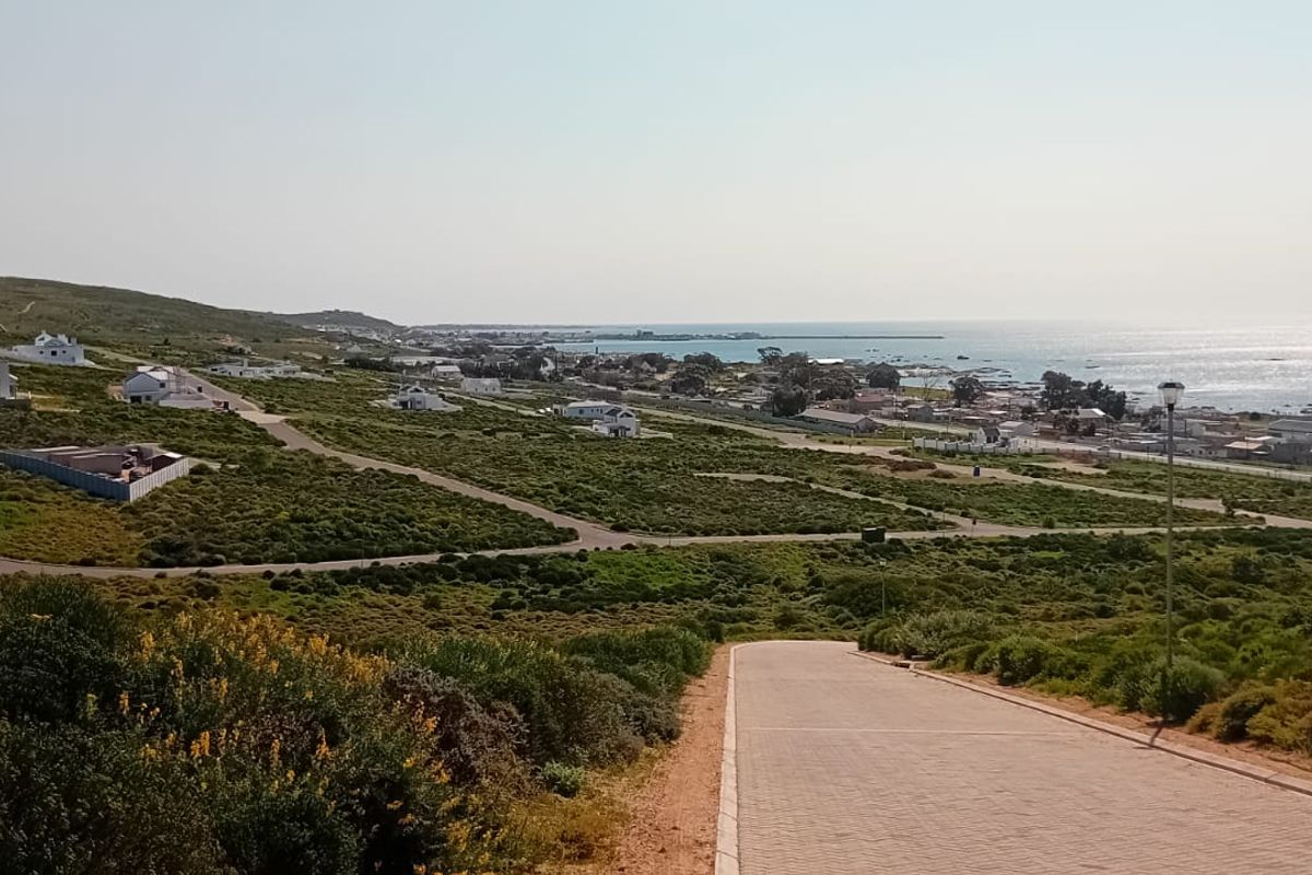A scenic elevated view overlooking the coastal landscape, surrounding residential properties, and the ocean horizon.