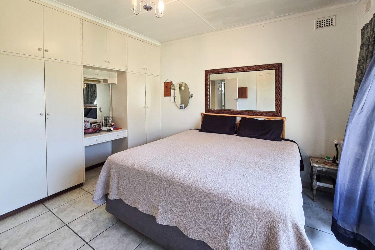 A bedroom featuring built-in cabinetry with an integrated vanity and tiled flooring.