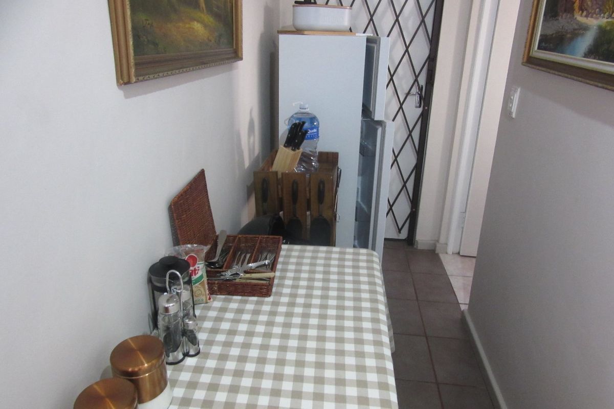 A functional kitchen area featuring tiled flooring and a security gate, providing access to the rest of the home.