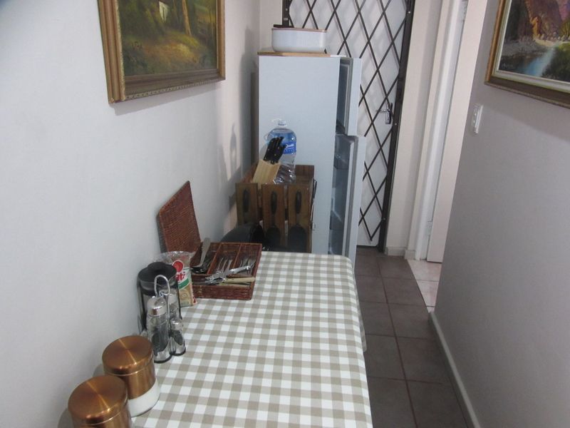 A functional kitchen area featuring tiled flooring and a security gate, providing access to the rest of the home.