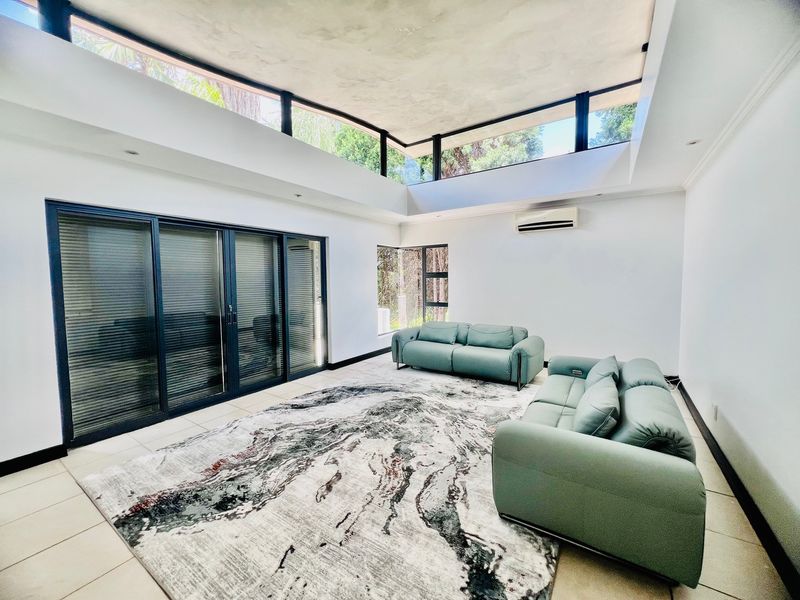 Spacious living room featuring high ceilings with clerestory windows, large sliding glass doors, and tiled flooring, providing ample natural light.