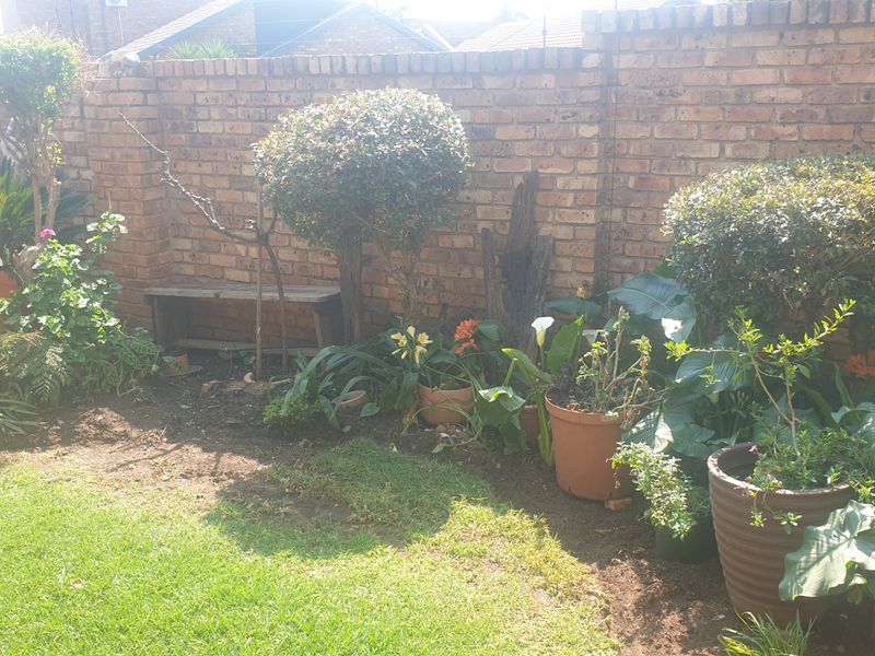 A private rear garden area featuring a established lawn and a solid brick boundary wall.