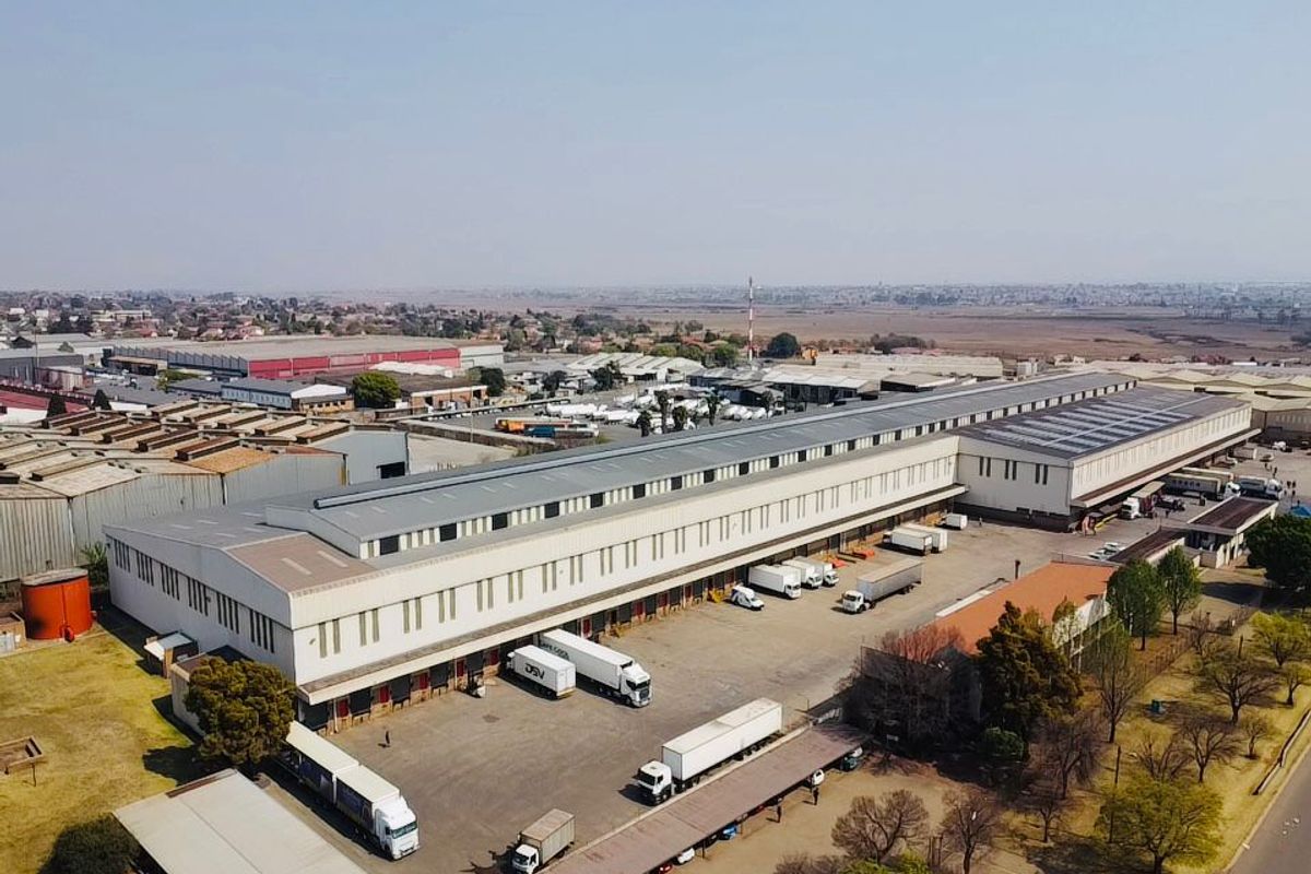 Aerial view of a large industrial warehouse facility featuring extensive loading docks, a paved yard, and significant storage capacity.