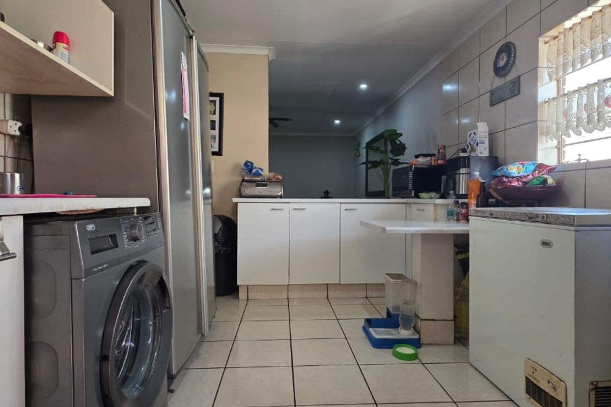 A functional kitchen featuring tiled flooring, built-in cabinetry, and a tiled backsplash, offering a practical layout for daily meal preparation.