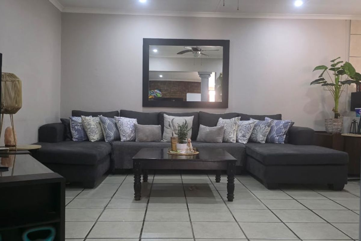 A comfortable living room featuring neutral wall tones, recessed downlighting, and durable ceramic floor tiles, providing a functional and inviting space.