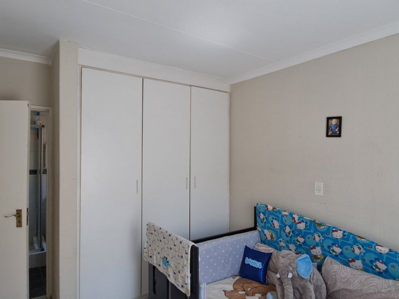 A bedroom featuring built-in cupboards and neutral wall finishes, providing functional storage space within the apartment.