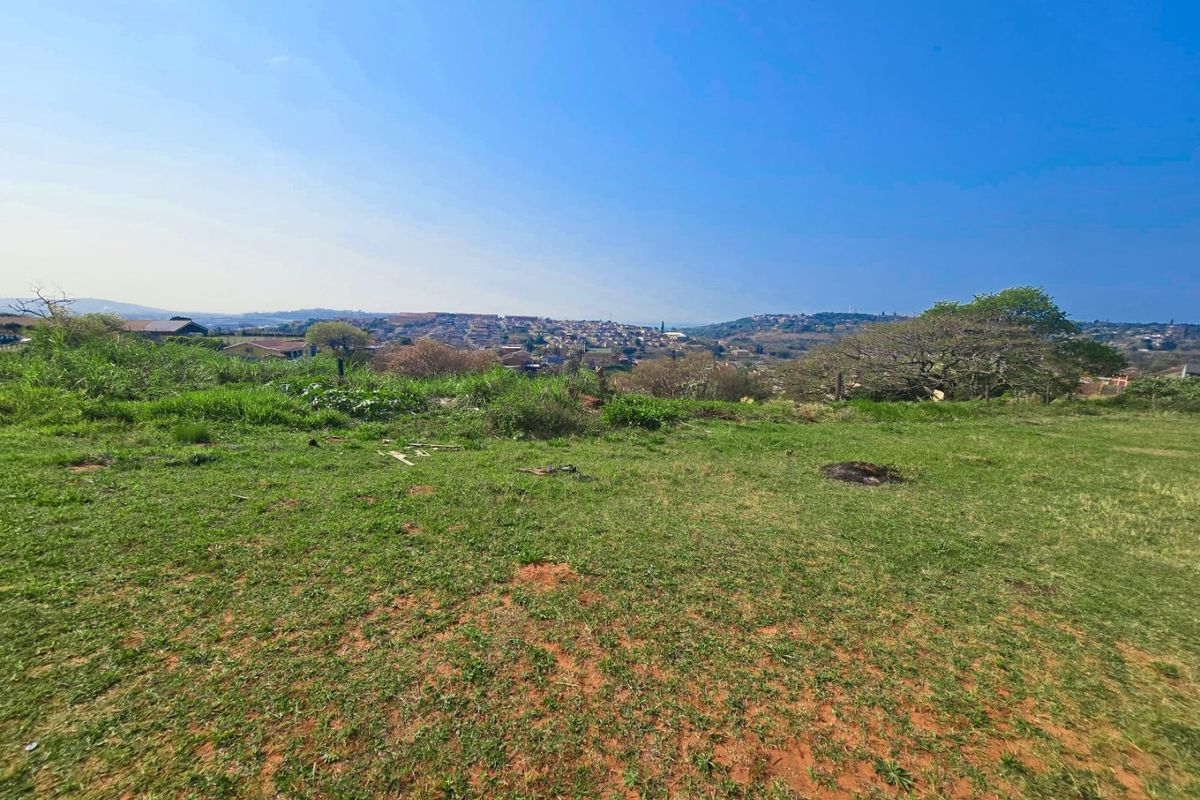 A wide-angle view of the vacant residential land, showcasing the natural landscape and surrounding neighborhood vistas.