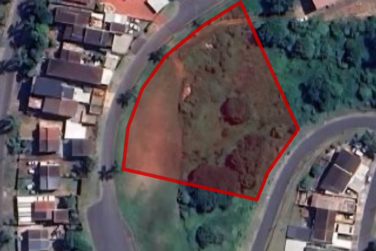 Aerial view of a vacant residential plot with red boundary lines indicating the property perimeter.