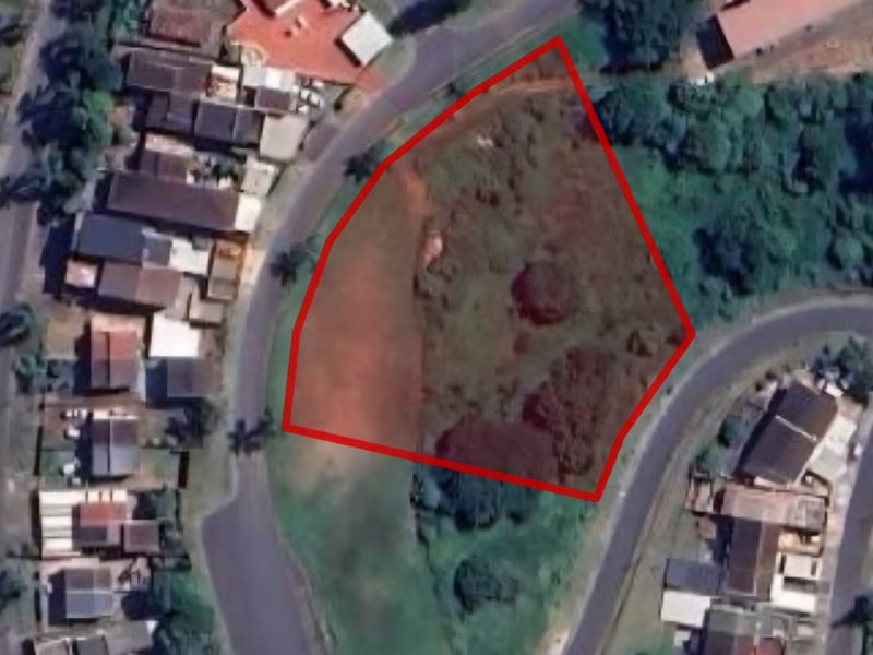 Aerial view of a vacant residential plot with red boundary lines indicating the property perimeter.