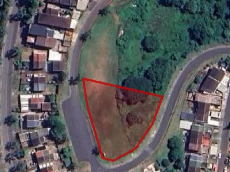 Aerial view of a vacant residential plot with red boundary lines indicating the property perimeter.