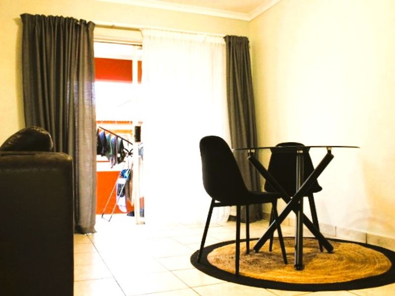 A living area featuring tiled flooring and a sliding glass door providing access to an outdoor balcony space.