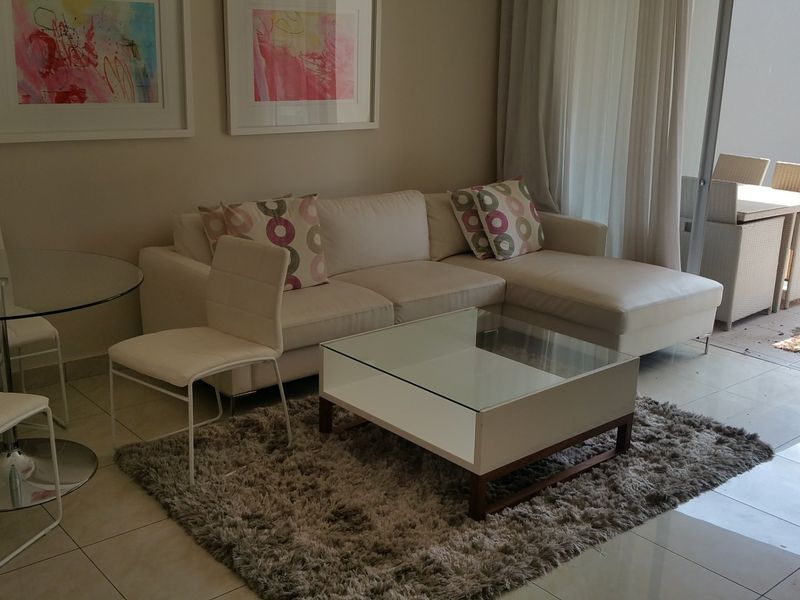 A bright and modern living area featuring tiled flooring and large sliding glass doors that provide seamless access to the outdoor patio space.