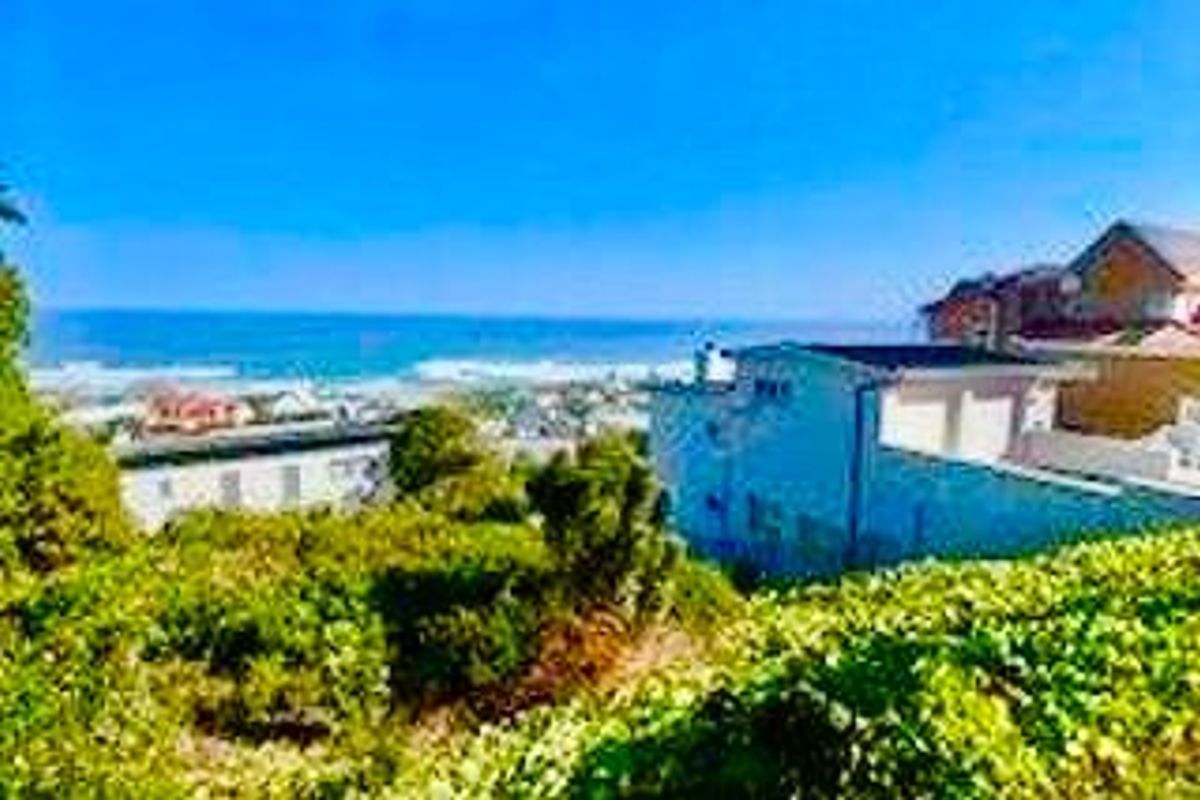 A scenic elevated view overlooking the coastline and ocean, showcasing the surrounding residential neighborhood and natural landscape.