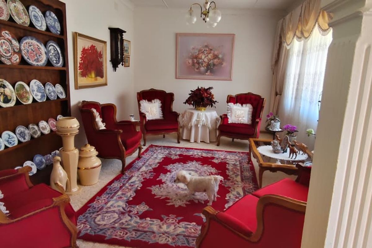 A traditional living room featuring a large built-in display shelving unit and a decorative column, offering a classic layout with ample space.