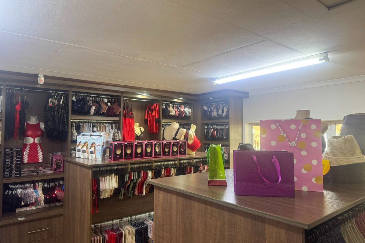 Commercial retail space featuring extensive built-in wooden cabinetry and shelving units, suitable for boutique display and storage.