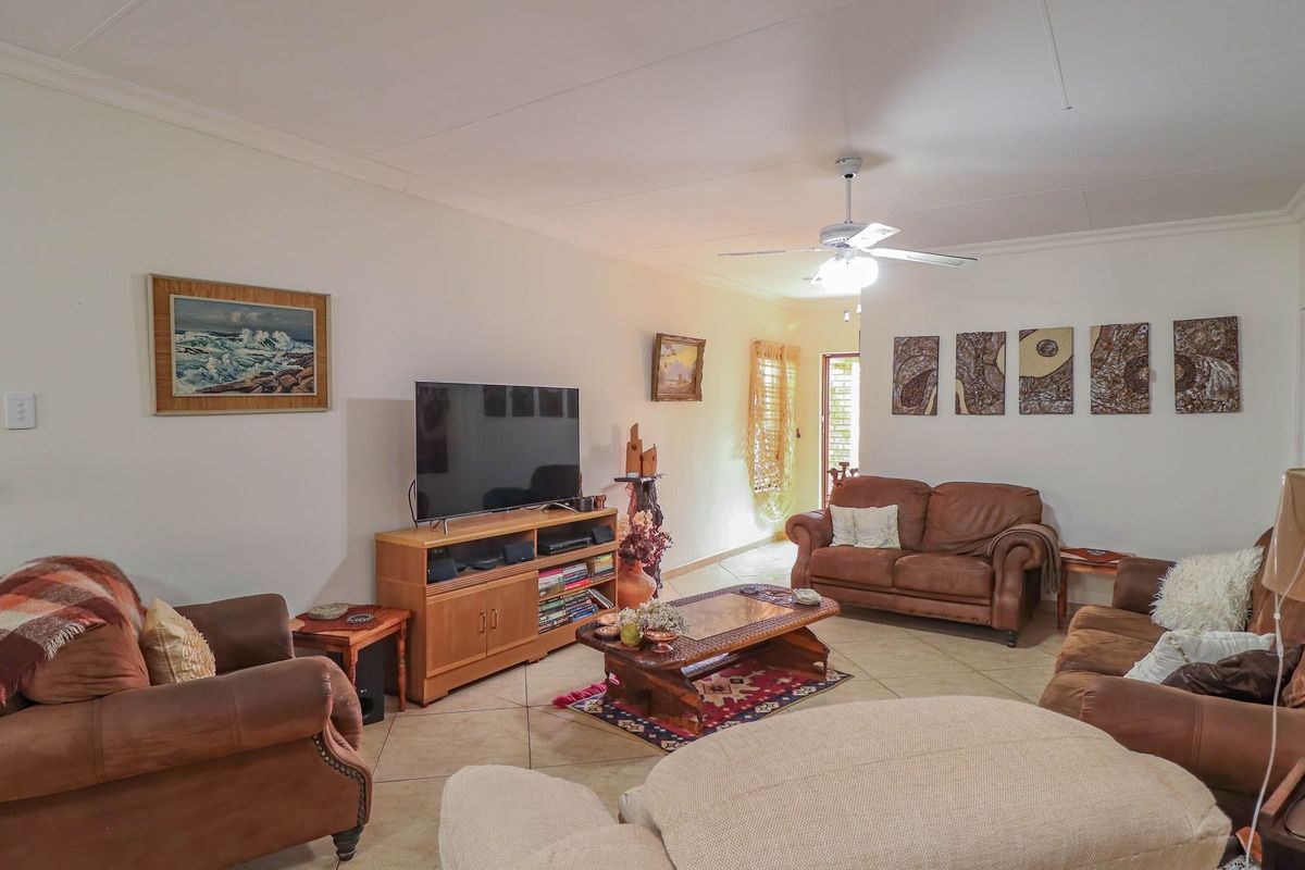 A spacious living room featuring tiled flooring and a ceiling fan, providing a comfortable and functional area for relaxation.