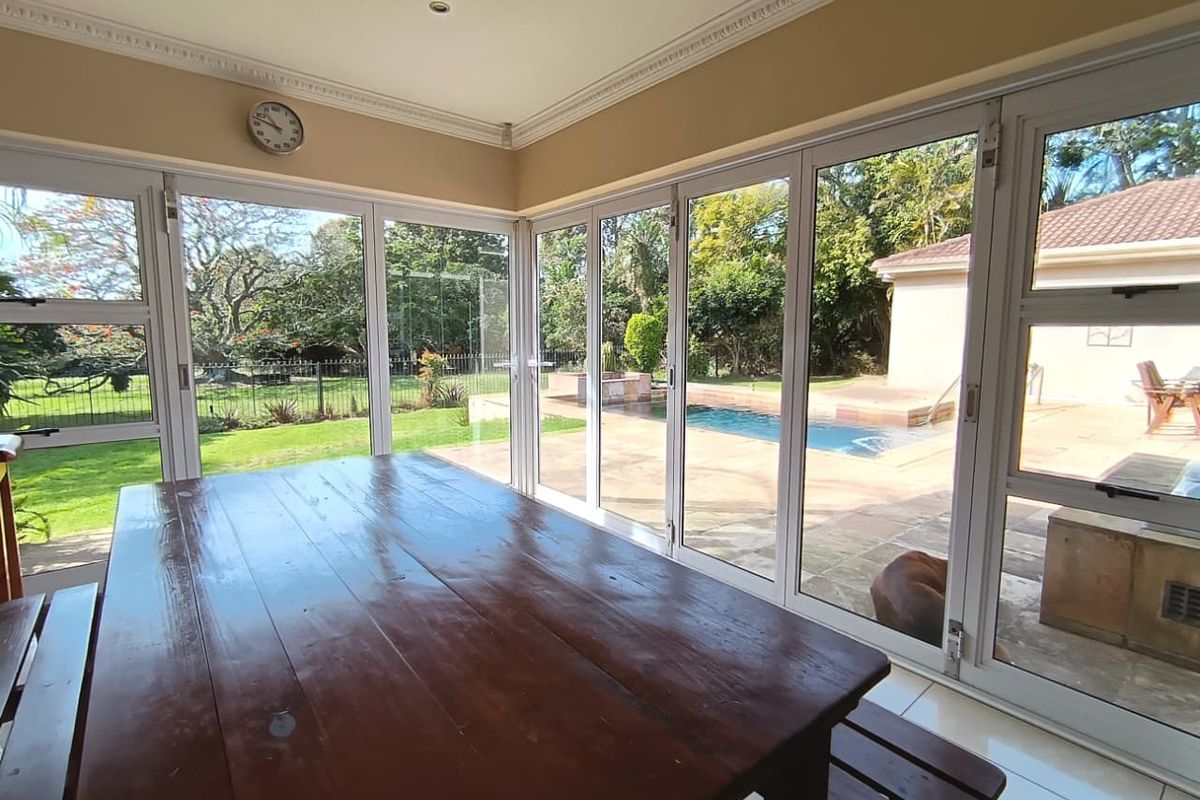 Bright living area featuring extensive bi-fold glass doors that provide seamless indoor-outdoor flow to the pool and garden area.